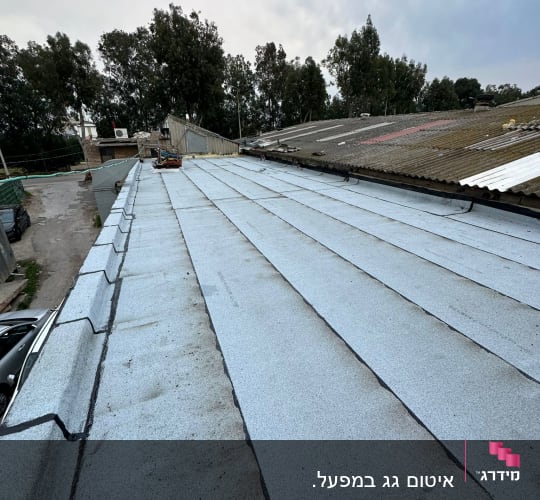 גג אטום ביריעות ביטומניות אפורות עם תפרים שחורים